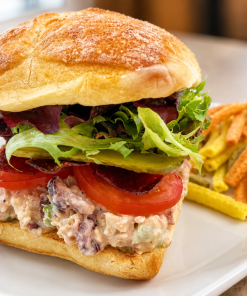 Clucker Mix chicken salad sandwich on ciabatta with kettle chips for fast beach food delivery in Naples Florida