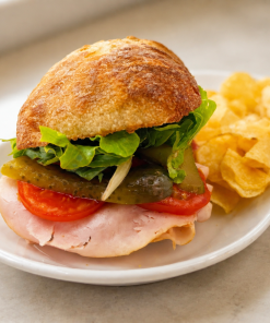 Honey Mother Clucker chicken sandwich on ciabatta with kettle chips for fast beach food delivery in Naples Florida