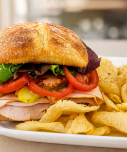 Quarrel In The Coop turkey and chicken sandwich on ciabatta with kettle chips for fast beach food delivery in Naples Florida