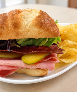 Vintage Ham-ingway Italian rosemary ham sandwich on ciabatta with kettle chips for fast beach food delivery in Naples Florida