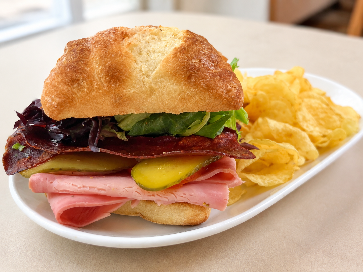 Vintage Ham-ingway Italian rosemary ham sandwich on ciabatta with kettle chips for fast beach food delivery in Naples Florida